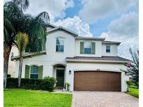 Charming two-story home with a well-manicured lawn, lush landscaping, and a two-car garage at 1016 Fountain Coin Loop, Orlando, FL 32828