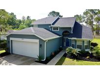 Charming two-story home featuring a well-manicured lawn and a two-car garage at 10747 Satinwood Cir, Orlando, FL 32825