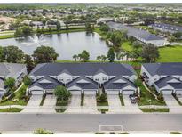 A lovely aerial view of townhomes with a pond and water feature creating a peaceful residential setting at 1275 Shallcross Ave, Orlando, FL 32828