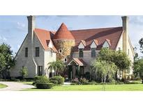 Charming estate featuring a stone turret, brick exterior, and clay tile roof at 1477 Shadwell Cir, Lake Mary, FL 32746