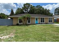 Charming single story home with a well-manicured lawn and a bright blue front door at 211 Valencia Rd, Debary, FL 32713