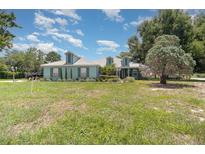 Charming one story home with a large front yard, mature trees, and attractive curb appeal at 2283 Knollwood Dr, Leesburg, FL 34748