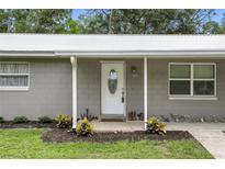 Charming single-story home featuring a covered porch and a white front door with decorative glass at 255 Belinda Dr, Deland, FL 32720