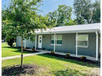 Charming single-story home featuring a metal roof, neutral gray color, tidy landscaping, and a welcoming walkway at 255 Belinda Dr, Deland, FL 32720