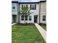 Charming two-story townhome featuring a landscaped front yard and inviting entrance at 3248 Merton Aly, Orlando, FL 32808