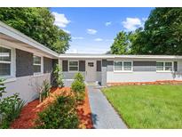 Charming home featuring gray brick accents, a well-manicured lawn, and tasteful landscaping at 3251 Wickersham Ct, Orlando, FL 32806