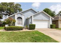 Charming single-story home featuring a two-car garage, landscaped yard, and light blue paint at 342 Lakebreeze Cir, Lake Mary, FL 32746