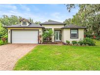 Charming home boasts lush landscaping, manicured lawn and a welcoming brick pathway to the front door at 489 Grape Ave, St Cloud, FL 34769