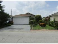 Charming single-story home with a well-maintained lawn and two-car garage at 5224 Florida Holly Dr, Orlando, FL 32811