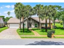 Charming home featuring palm trees, a brick driveway and walkway, and a well-maintained lawn at 526 Sabal Trail Cir, Longwood, FL 32779