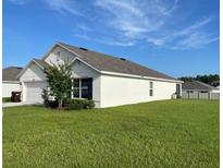 Well-maintained home featuring lush green lawn and white stucco exterior at 7172 Sw 135Th Pl, Ocala, FL 34473