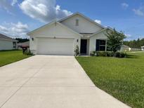 Charming single-story home featuring a well-maintained lawn and a two car garage at 7172 Sw 135Th Pl, Ocala, FL 34473