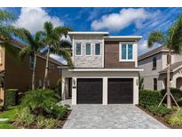 Beautiful two-story home featuring a modern design, manicured landscaping, and a two-car garage, making it a perfect Gathering residence at 884 Golden Bear Dr, Reunion, FL 34747