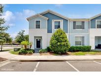 Charming two-story townhome featuring a well-maintained lawn and inviting front entrance at 8900 Sydney Ave, Kissimmee, FL 34747