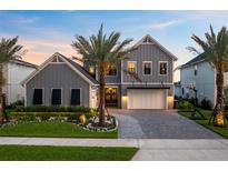 Beautiful gray two-story home featuring a manicured front yard and paver driveway at 9352 Santorini Dr, Orlando, FL 32827