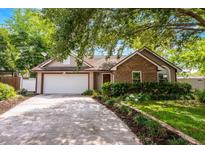 Charming single-story home with brick and siding, mature landscaping, and a two-car garage at 1010 Leinhart Ct, Oviedo, FL 32765