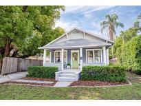 Charming single-story home with a well-manicured lawn, inviting porch, and a vibrant green front door at 112 E Spruce St, Orlando, FL 32804