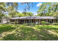 Charming brick ranch home with a well-manicured lawn and mature landscaping at 220 Morton Ln, Winter Springs, FL 32708