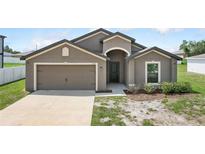 Charming home featuring a two-car garage and covered entryway for curb appeal at 257 Fig Ct, Kissimmee, FL 34759