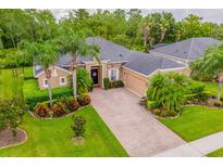 Beautiful single-story home with lush landscaping, brick driveway, and stone accents at 3753 Heirloom Rose Pl, Oviedo, FL 32766