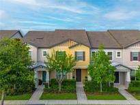 Townhome with meticulously maintained lawn, shrubs and tidy landscaping around the walkway at 5029 Walker St, St Cloud, FL 34771
