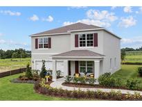 Two-story home with a landscaped front yard, covered entryway, and two-car garage showcasing classic suburban living at 5099 Marshelder St, Apopka, FL 32712