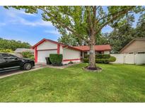 Charming one story home featuring a well manicured lawn and an attached two car garage at 8040 Sagebrush Pl, Orlando, FL 32822