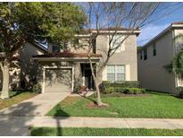 Charming two-story home with a well-manicured lawn, complemented by a two car garage and mature shade trees at 8894 Candy Palm Rd, Kissimmee, FL 34747