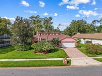 Charming single-story home with a brick driveway, mature landscaping, and a well-manicured front lawn at 9326 Bay Vista Estates Blvd, Orlando, FL 32836
