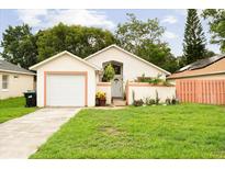 Charming single-story home with attached garage, vibrant landscaping and a well-manicured lawn at 9814 Piney Point Cir, Orlando, FL 32825