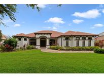 Charming one-story home with lush green lawn, terracotta tile roof, and well-manicured landscaping at 12663 Hawkstone Dr, Windermere, FL 34786