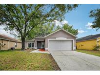 Charming single-story home featuring a well-maintained lawn and attached two-car garage at 14565 Lycastle Cir, Orlando, FL 32826