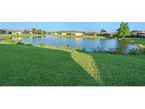 Lush green backyard overlooking a serene lake with neighborhood homes in the distance at 307 Monterey St, Kissimmee, FL 34759