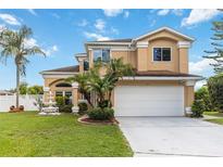 Charming two-story home with lush landscaping, palm trees, and a beautiful fountain at 344 Blue Bayou Dr, Kissimmee, FL 34743