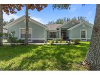 Charming one-story home featuring a lush green lawn and inviting curb appeal with stone accents and mature trees at 36646 Oconee Ave, Eustis, FL 32736
