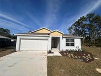 Charming single-story home with a manicured lawn, a two-car garage, and neutral tones at 3950 Alba Dr, Indian Lake Estates, FL 33855