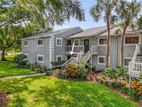 Condo exterior featuring lush landscaping and a private entrance with stairway at 4102 Plantation Cove Dr # 201, Orlando, FL 32810