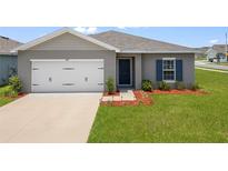 Charming single-story home featuring a well-maintained lawn and attached two-car garage at 489 Panaro Ln, Haines City, FL 33844