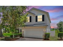 Two story home with well-manicured landscaping, attached garage and neutral paint at 546 Windsor Pl, Davenport, FL 33896