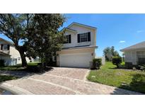 Charming two-story home with brick driveway, attached garage, and well-maintained landscaping at 546 Windsor Pl, Davenport, FL 33896