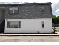 The exterior of the building shows a gray roof and a white lower level, with windows and landscaping at 1000 S Semoran Blvd # 415, Winter Park, FL 32792