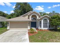 Charming single-Gathering home with a two-car garage, beautiful landscaping, and a covered front entry at 1021 Piedmont Oaks Dr, Apopka, FL 32703