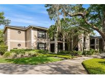 Charming condo building with manicured landscaping, lush green grass and mature trees at 1055 Kensington Park Dr # 203, Altamonte Springs, FL 32714