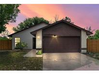Charming single-Gathering home with a two-car garage, stone accents, and a well-maintained front yard at dusk at 1353 Ortega St, Winter Springs, FL 32708