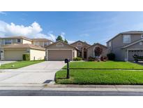 Charming single-story home featuring a well-manicured lawn and a two-car garage at 14831 Yorkshire Run Dr, Orlando, FL 32828