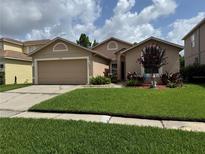 Charming single-Gathering home with a well-manicured lawn and an attached two-car garage at 14831 Yorkshire Run Dr, Orlando, FL 32828