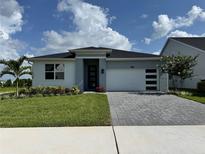 Charming single-story home with a modern design, beautiful landscaping, and a paved driveway at 1646 Pinecliff Dr, Apopka, FL 32703