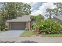 Charming brick home featuring an attached garage, mature landscaping, and a well-maintained front yard at 200 Hummingbird Ln, Longwood, FL 32779