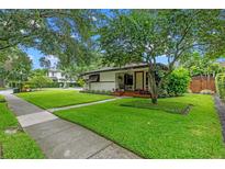 Charming home with lush green lawn and mature trees offering curb appeal and natural shade at 2190 Temple Dr, Winter Park, FL 32789