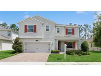 Charming two-story home features red shutters, attached garage, and beautifully maintained front lawn at 2279 Mountain Pine St, Ocoee, FL 34761